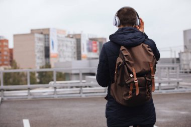 Adam müzik açık havada, arkadan görünüm dinlerken kulaklık