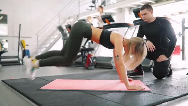 Instrutor de fitness controla como a mulher faz exercício no ginásio — Vídeo de Stock