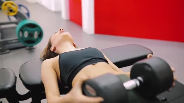 Mujer trabajando en gimnasio con pesadas mancuernas — Vídeo de stock