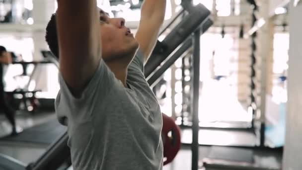 Unga nybörjare man utövar i gymträning med utbildning apparater — Stockvideo