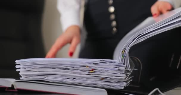 Closeup of woman searching an information in a folder at office — Stock Video