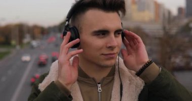 Genç adam zevk City kulaklık ile müzik dinleme