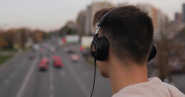 市ではヘッドフォンで音楽を聴く若い男 — ストック動画