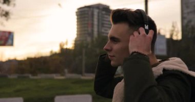 Adam müzik kulaklık ile akşam şehirde yürüyüş tadını çıkarın
