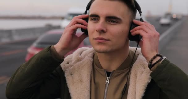 Νεαρός Άνδρας Ακούτε Μουσική Ακουστικά Περπατώντας Στην Πόλη Γέφυρα — Αρχείο Βίντεο