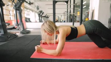 Spor salonunda, bacaklarını fitness merkezi üzerinde ağırlık egzersiz kadın