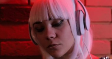 Beyaz peruk kulaklıklar, kırmızı ışık tuğla duvar kullanarak müzik olağandışı seksi kız