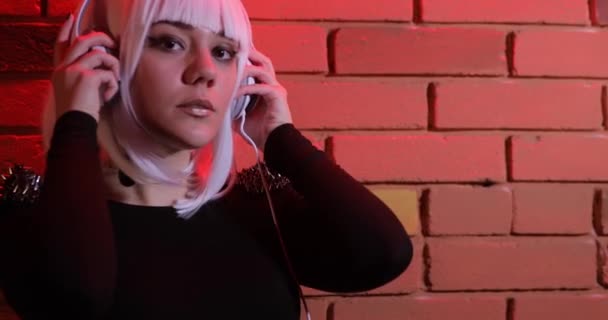 Beyaz Peruk Kulaklıklar Kırmızı Işık Tuğla Duvar Kullanarak Müzik Olağandışı — Stok video