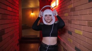 Seksi alışılmadık kız düşünce kırmızı ışık koridor gidiş kulaklık ile müzik