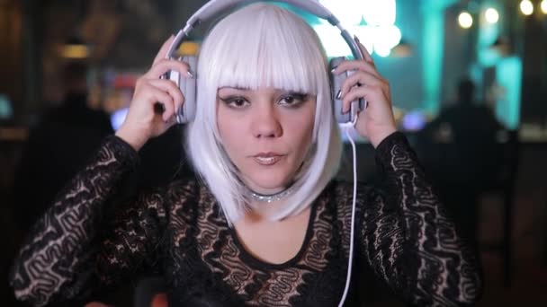 不寻常的金发女孩听音乐在酒吧使用耳机 — 图库视频影像