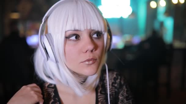 異常なブロンドの女の子 バーで音楽を聴くヘッドフォンを使用して — ストック動画