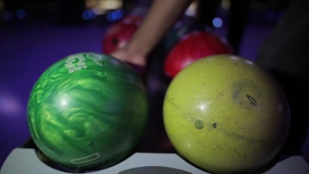 Řádky z bowlingové koule, mužské ruky vzít jeden z nich — Stock video