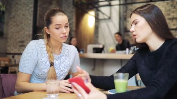 Vrouwen vrienden foto's in smartphone kijken naar café — Stockvideo