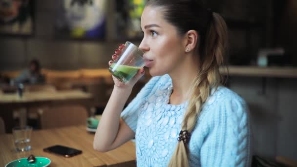 Frau trinkt Matcha Latte im Café — Stockvideo