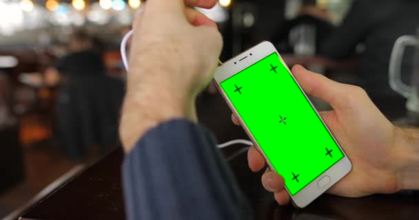 Tela verde, conectando o cabo de fones de ouvido no smartphone — Vídeo de Stock