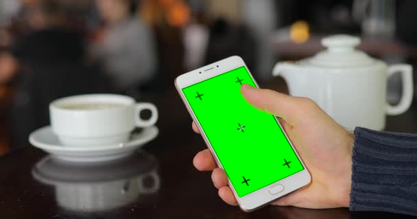 Зелений екран смартфона, рука за допомогою цифрового дисплея в кафе — стокове відео