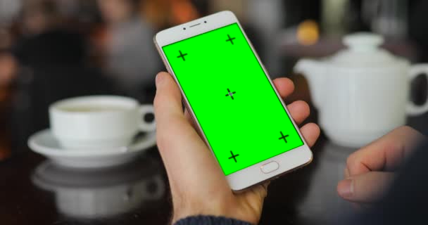 Écran vert du smartphone, à la main en utilisant l'affichage numérique dans le café — Video