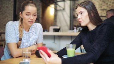 İki kadın görünümlü fotoğraflar smartphone içinde gülüyor