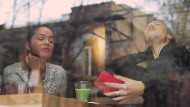 Mulheres amigas levam tiro selfie móvel em um café atrás da janela — Vídeo de Stock