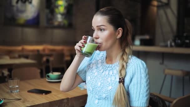 Woman drinking matcha latte in cafe — Stock Video