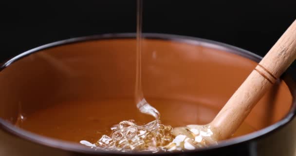 Мед наливается в миску крупным планом. Здоровый натуральный сладкий десерт . — стоковое видео