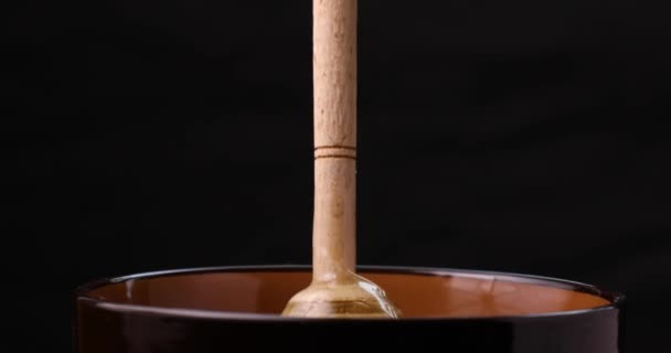 Honung hälla i bowl närbild. Svart bakgrund. — Stockvideo