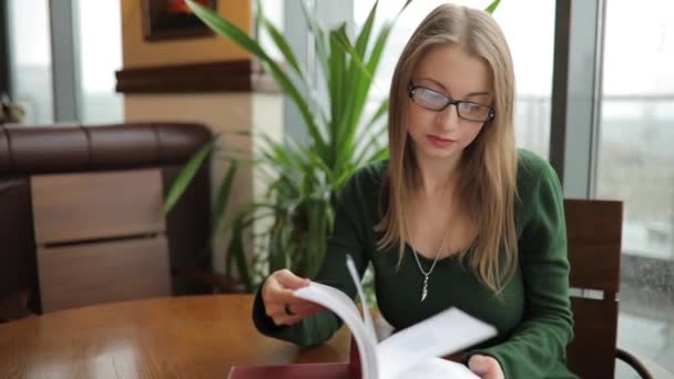 Mulher virar páginas no livro sentado no café — Vídeo de Stock