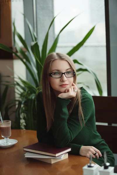 Portrait of intelligent woman sitting with books in cafe — Stock Photo, Image