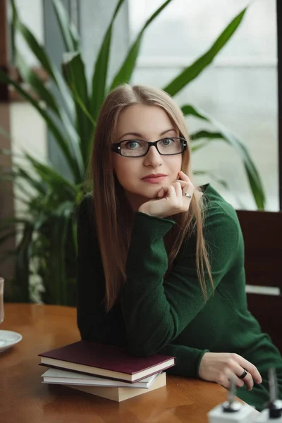 Portret van intelligente vrouw zitten met boeken in café — Stockfoto