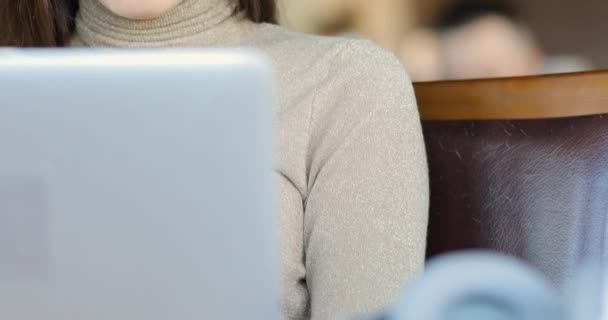 Joven blogger trabajando por computadora portátil en la cafetería, editando un nuevo video para su blog — Vídeo de stock