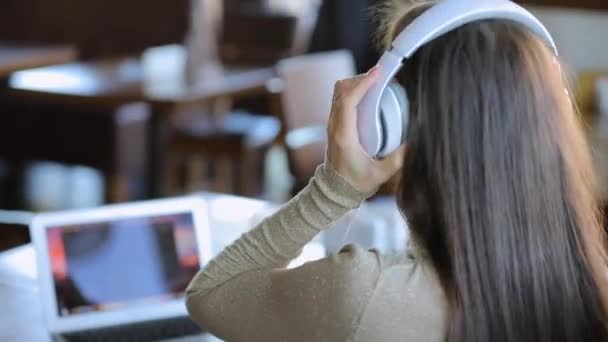 Joven blogger trabajando por computadora portátil en la cafetería, editando un nuevo video para su blog — Vídeos de Stock