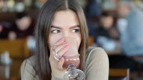 Nahaufnahme Porträt einer fröhlichen jungen Frau, die im Café Kakao trinkt — Stockvideo