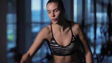 Atletik kadının spor salonunda bir ip ile çapraz uygun egzersizler yapması