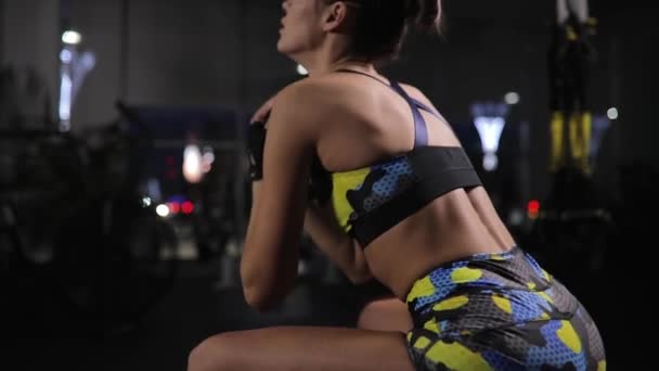 Schöne Frau, die im Fitnessstudio trainiert, hockt mit Gewicht in militärischem Sportkostüm — Stockvideo