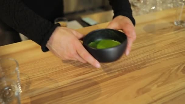 Your matcha tea in bowl is ready, put on the table for client — Stock Video