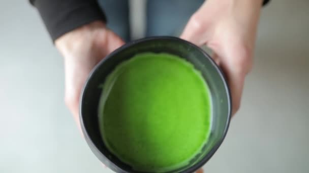 Thé Matcha dans un bol, vue du dessus de la boisson verte dans les mains des femmes — Video
