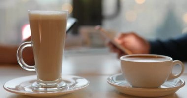 Internet bağımlılığı. Kahve closeup fincan yudumlarken telefonları kullanarak.