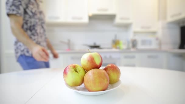 Onherkenbaar man nemen, gooien en vangen van verse schone apple van plaat — Stockvideo