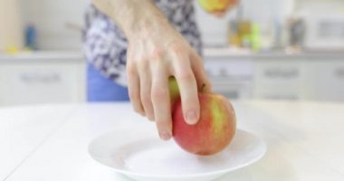 Tanınmayan adam taze temiz elma plaka koyar.