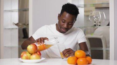 Ağır çekim bir Afrikalı-Amerikalı adam vermek beni mutfakta meyve suyu
