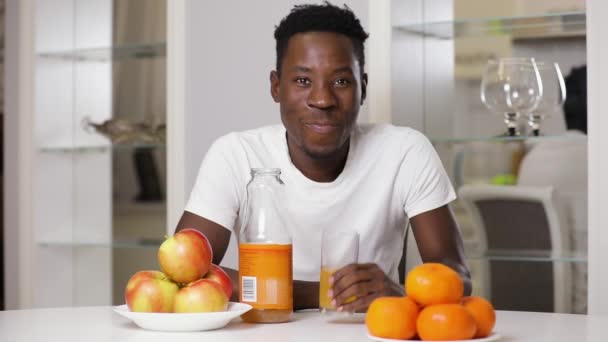 Αργή κίνηση αφρικανική αμερικανική άνδρα να μου δώσει ένα χυμό στην κουζίνα — Αρχείο Βίντεο