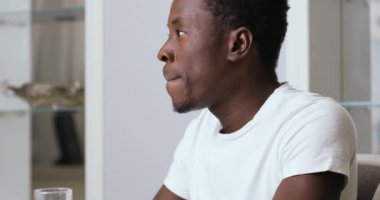 Afrika kökenli Amerikalı adam mutfakta suyu içme