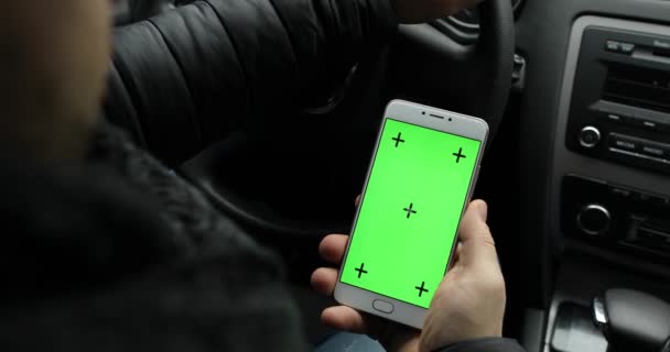 Hombre sosteniendo la pantalla verde vacía del teléfono inteligente en el coche, croma key — Vídeos de Stock