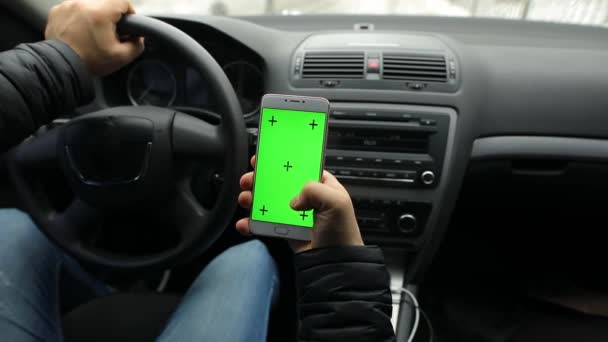 Homem segurando a tela verde vazia do smartphone no carro, chave chroma — Vídeo de Stock