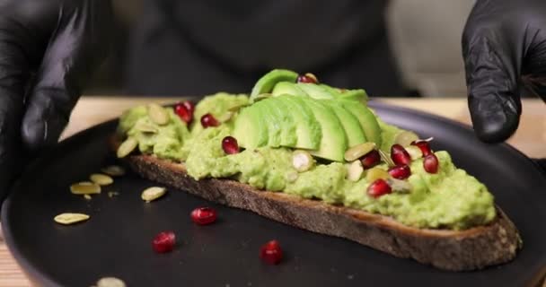 Kuchař, zdobení avokádový toast se salátem — Stock video