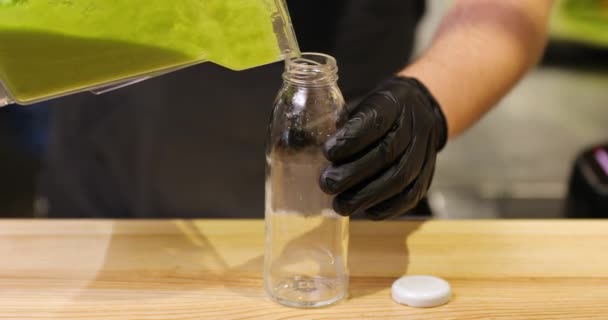 Verter smoothie verde em garrafa no balcão do bar do restaurante — Vídeo de Stock