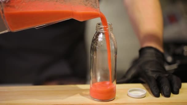 Orangen-Smoothie in Flasche in Restaurant-Theke gießen — Stockvideo