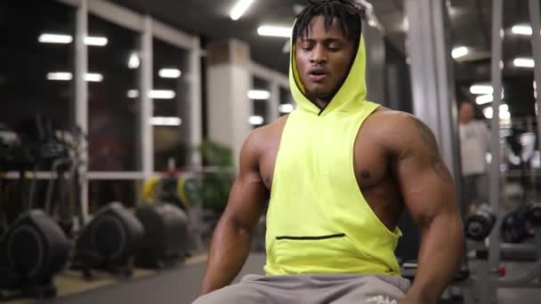 Homme afro-américain fatigué assis dans la salle de gym — Video