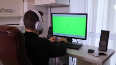 Evde yeşil ekran chroma anahtar ile PC bilgisayar kullanan adam