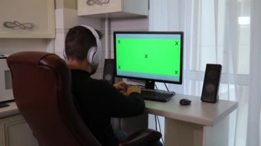 Evde yeşil ekran chroma anahtar ile PC bilgisayar kullanan adam